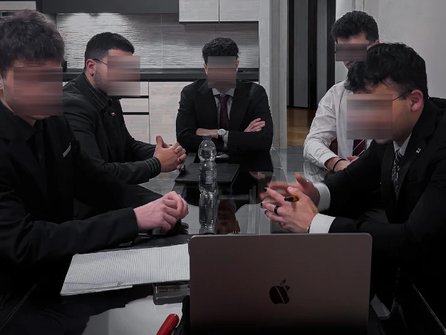 Andrei e il suo team attorno a un tavolo, davanti a un portatile.